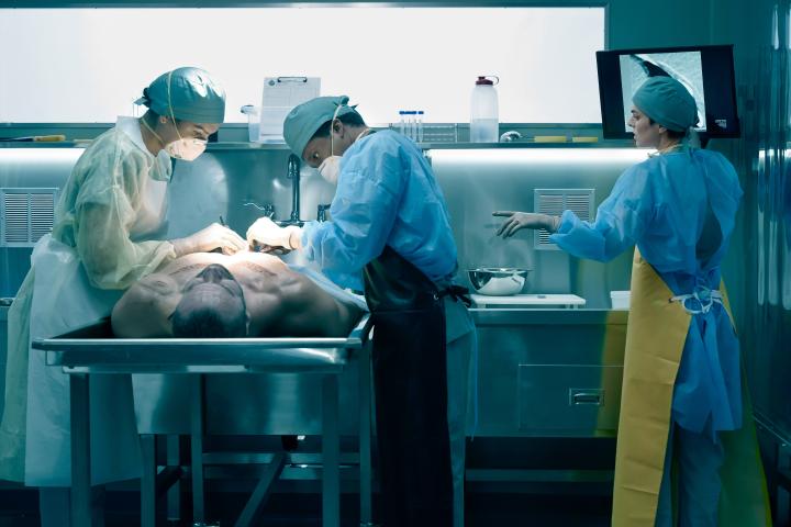 Dr. River Baitz (Kiley May) and Dr. Dwayne Allan (Lovell Adams-Gray) doing their pathologist thing with their boss, the coroner herself, Jenny Cooper (Serinda Swan).