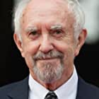 Jonathan Pryce به عنوان Sir Stuart Strange