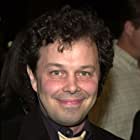 Curtis Armstrong به عنوان Ahmet Ertegun