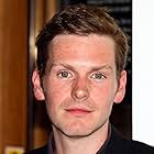 Shaun Evans به عنوان John Sweeney