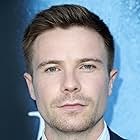 Joe Dempsie به عنوان Derek Mahon